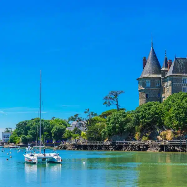 Château avec voiliers sur l'eau.