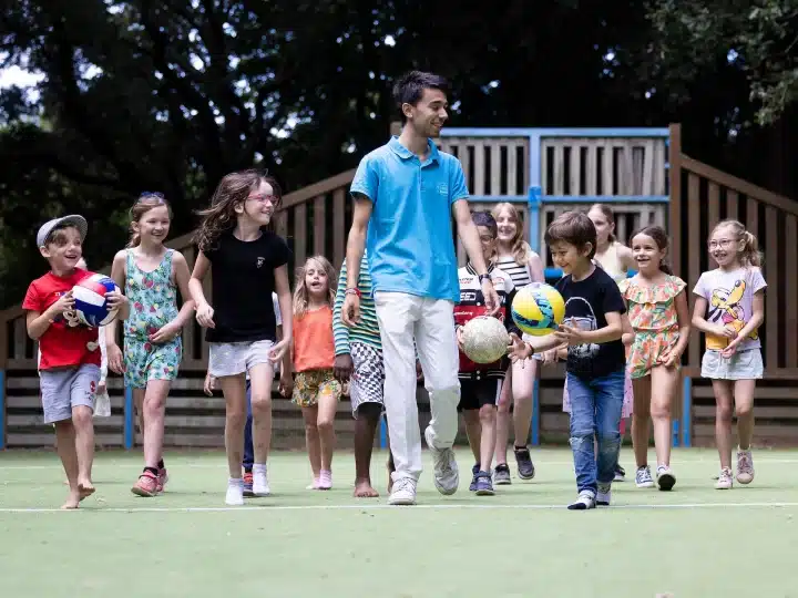Enfants jouant au football sur un terrain.