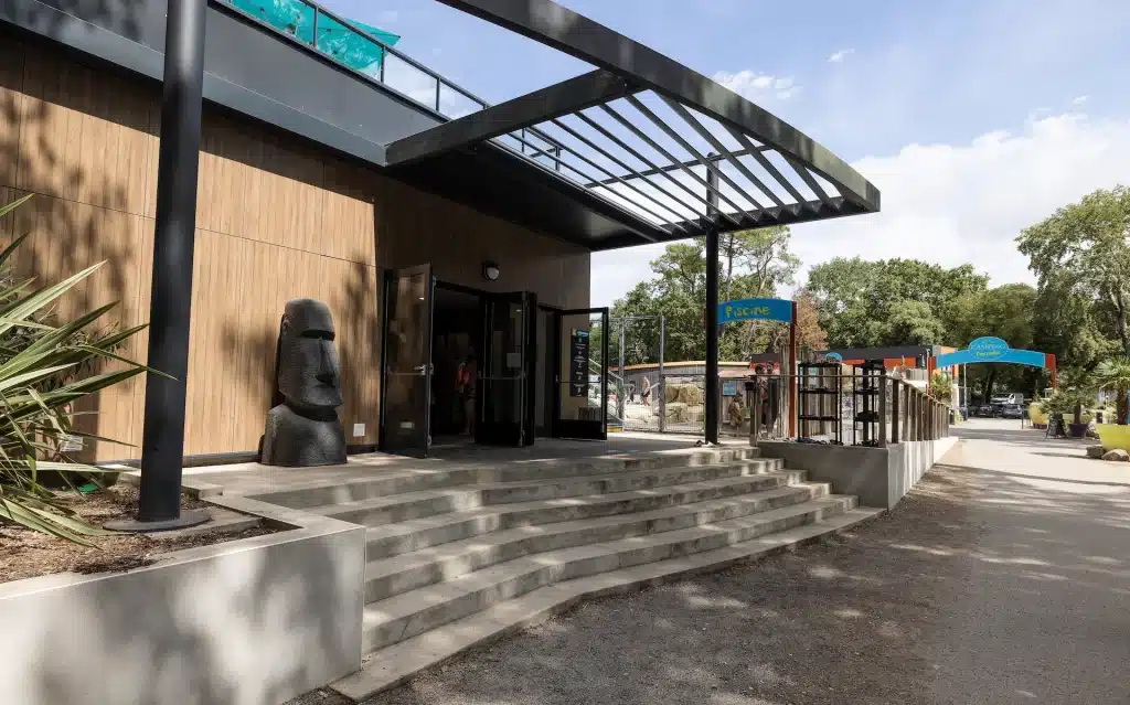 Entrée de bâtiment moderne avec statue de pierre.