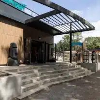 Entrée de bâtiment moderne avec statue de pierre.