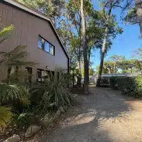 Bâtiment entouré d'arbres et de végétation.