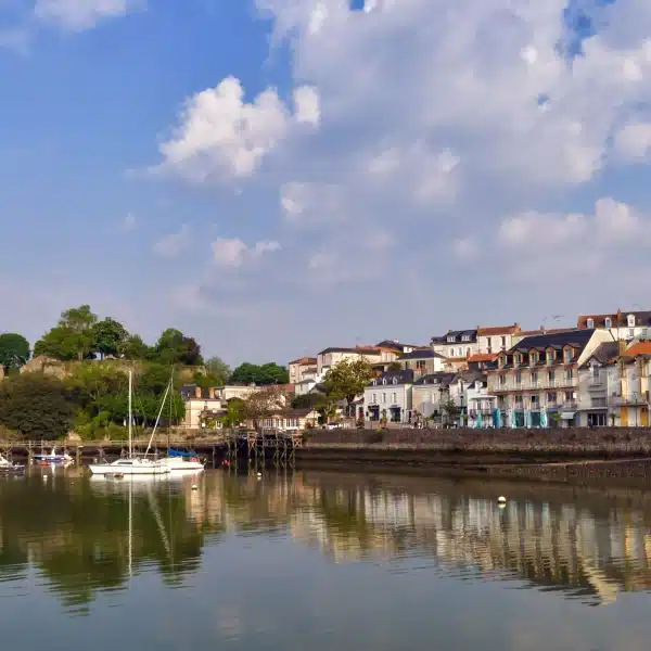 Château et bateaux au bord de l'eau, ciel bleu.