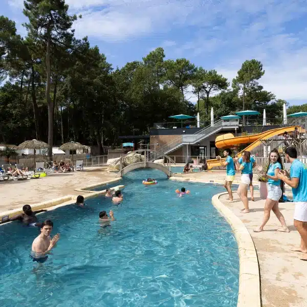 Piscine extérieure avec toboggan et baigneurs.