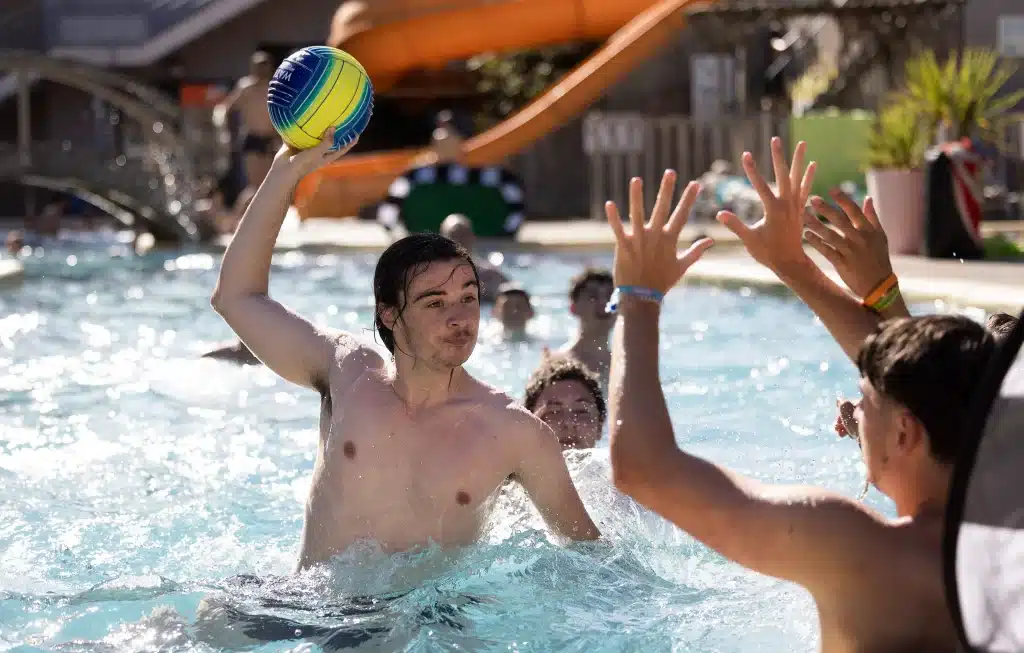 Jeunes jouant au ballon dans une piscine.