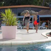 Personnes marchant près de la piscine.