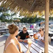 Personnes discutent autour d'une table au soleil.