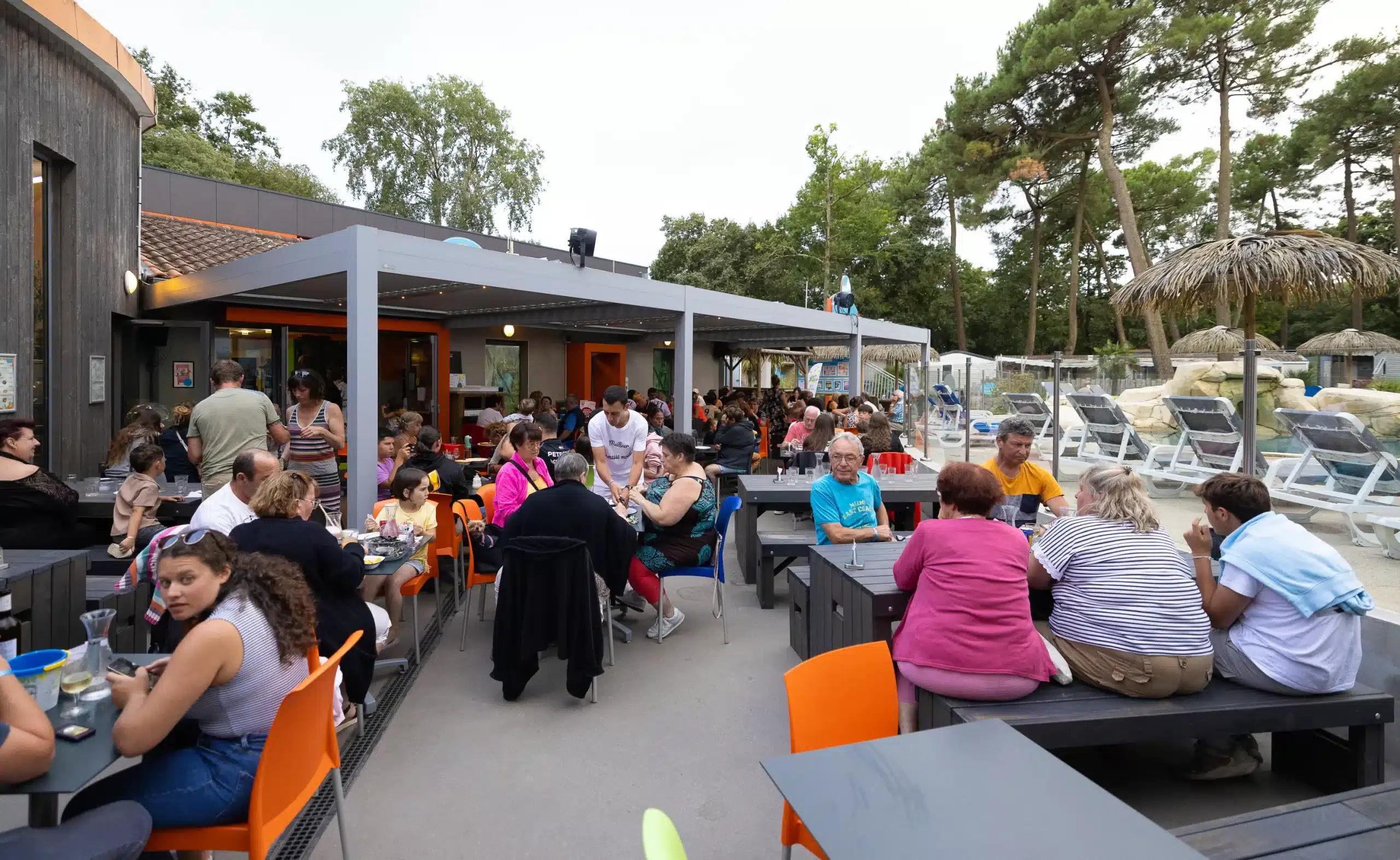 Terrasse de restaurant bondée en plein air.