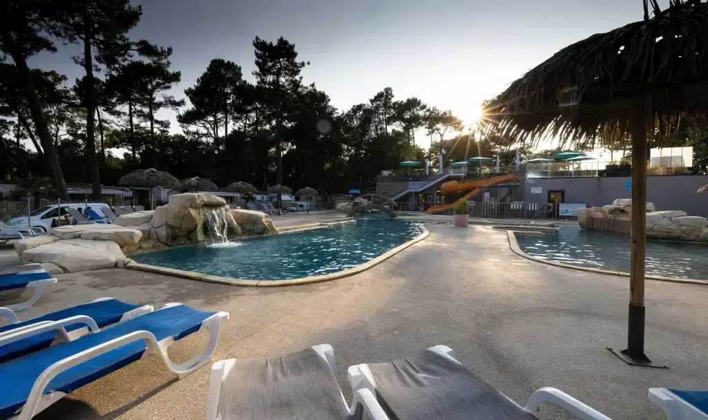 Piscine extérieure avec chaises longues et toboggans.
